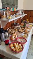 a table with many different types of food on it at Pousada Sino dos Ventos in Campos do Jordão