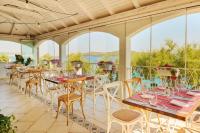 un patio con tavoli, sedie e finestre di Amadria Park Camping Trogir - Mobile Homes 2 a Seget Vranjica