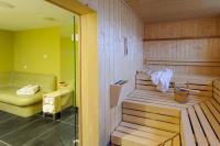 a sauna with a bench and a chair in a room at Novotel München City Arnulfpark in Munich