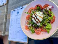 Un plato de ensalada con tomates y un huevo encima. en Hotel Restaurant Ostsee-Anker, en Langballig