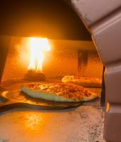 Er komen twee pizza's uit de oven. bij Auntie Gigi's Place in Tagaytay