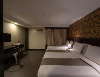 Una habitación de hotel con tres camas y un escritorio. en GT Hotel Jaro, en Iloilo City