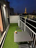 a table on a balcony with a view of the eiffel tower at Appartement vue Tour Eiffel paris 16 Eme in Paris