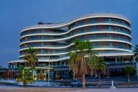 Un gran edificio con palmeras delante. en FASQ Hotel, en Nouakchott