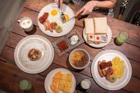 a wooden table topped with plates of breakfast food at The Quartier Hotel Phromphong - Thonglor in Bangkok