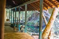 een veranda met uitzicht op een rivier en een boom bij Sama Retreats - Kosgoda in Kosgoda