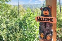 ein Teddybär, der ein Willkommensschild an einer Stange hält in der Unterkunft Cabin In The Smokeys in Gatlinburg