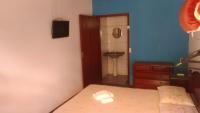 Un dormitorio con una cama y un baño con lavabo. en Pousada Miau, en Foz do Iguaçu