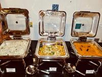 três bandejas de comida sobre uma mesa com colheres em The Windchimes Retreat Coorg em Virajpet