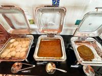 um grupo de bandejas com diferentes tipos de alimentos em The Windchimes Retreat Coorg em Virajpet