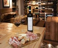 サウゼ・ドゥルクスにあるOrso Bianco Hotel & Chaletのワイン1本とワイングラス2杯(テーブル上)