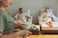 two men and a woman sitting on chairs in a living room at Stay Wellbeing & Lifestyle Resort in Rawai Beach