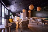 Una sala de espera con sillas, mesas y ventanas. en Ola Boutique Hotel, en San Juan