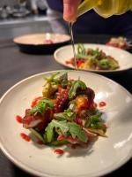 Maison Bérard Hôtel - Restaurant - Spa في لا كادير دازور: شخص يصب صلصة على صحن من الطعام