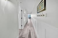 einen weißen Flur mit weißen Wänden und Holzböden in der Unterkunft Beautiful Updated Pelican Beach Unit!!! in Destin