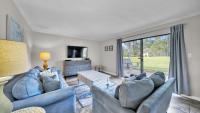 ein Wohnzimmer mit zwei blauen Sofas und einem großen Fenster in der Unterkunft Cozy renovated ground floor unit - Golf Villa - on the Golf Course in Destin