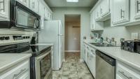 eine Küche mit weißen Schränken und einem weißen Kühlschrank in der Unterkunft Cozy renovated ground floor unit - Golf Villa - on the Golf Course in Destin