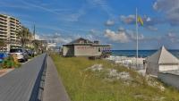 einen Bürgersteig neben einem Strand mit einem Gebäude in der Unterkunft Cozy renovated ground floor unit - Golf Villa - on the Golf Course in Destin