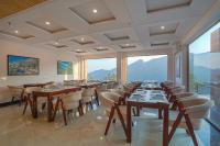 Un comedor con mesas y sillas y grandes ventanales. en The Sanawar Heights I Kasauli I New Property, en Kasauli