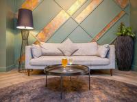a living room with a couch and two glasses on a table at Mercure Cardiff North Hotel in Cardiff