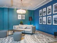 a blue living room with a couch and a table at Mercure Cardiff North Hotel in Cardiff