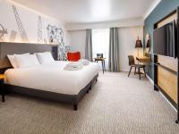 a hotel room with a bed and a flat screen tv at Mercure Cardiff North Hotel in Cardiff
