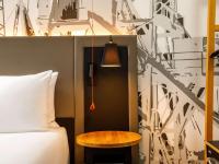 a bedroom with a bed and a table next to a bed at Mercure Cardiff North Hotel in Cardiff