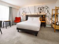 a hotel room with a bed and a chair at Mercure Cardiff North Hotel in Cardiff