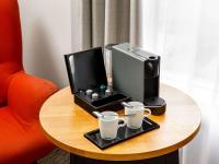 a desk with a computer and two cups on a table at Mercure Cardiff North Hotel in Cardiff