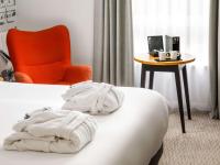 a hotel room with a bed and a chair and a table at Mercure Cardiff North Hotel in Cardiff
