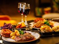 a table with plates of food and a glass of wine at Mercure Cardiff North Hotel in Cardiff