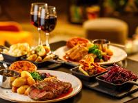 a table with plates of food and a glass of wine at Mercure Cardiff North Hotel in Cardiff