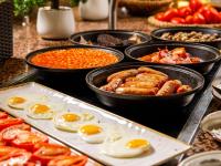 a buffet of food with eggs and other foods at Mercure Cardiff North Hotel in Cardiff