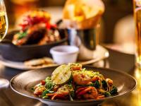 a plate of food with shrimp and vegetables on a table at Mercure Cardiff North Hotel in Cardiff