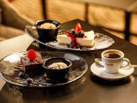 a table with three plates of desserts and cups of coffee at Mercure Cardiff North Hotel in Cardiff
