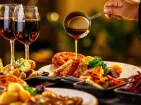 a person pouring wine into a plate of food at Mercure Cardiff North Hotel in Cardiff