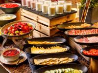 a buffet with many different types of food in pans at Mercure Cardiff North Hotel in Cardiff