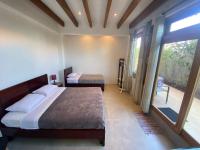 a bedroom with two beds and a large window at Black Pearl in Puerto Villamil