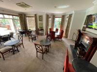 uma sala com mesas e cadeiras e um piano em Redlands Hotel em Pietermaritzburg