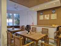 a dining room with wooden tables and chairs at The Sunset Villa in Dhiffushi