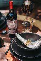 Un cuchillo en un plato junto a una botella de vino. en Kokoro Mio Hotel & Wellnes, en Xul-Ha