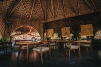 Un restaurante con mesas y sillas de madera y un techo en Kokoro Mio Hotel & Wellnes, en Xul-Ha