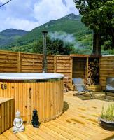 a hot tub on a wooden deck with mountains in the background at Le Monné - Gîte &amp; Spa tout confort in Campan
