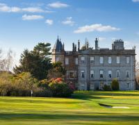 un antiguo castillo con un patio verde y un campo de golf en Dalmahoy Hotel &amp; Country Club, en Edimburgo