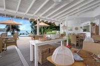sala de estar con mesa y sillas y patio en The Bay Seychelles Boutique Hotel and Apartments, en Anse a La Mouche