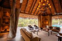una sala de estar con sofás y un árbol en Kapama River Lodge, en Kapama Private Game Reserve