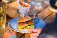 Un plato azul con un sándwich y papas fritas sobre una mesa. en Hotel Restaurant Berghaus Malbun Buchserberg, en Buchs