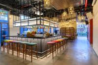 芹苴Wink Hotel Can Tho Centre, Unscripted by Hyatt的餐厅里酒吧里摆放着五颜六色的凳子