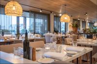 ein Restaurant mit weißen Tischen und Stühlen und einer Flasche Wein in der Unterkunft Luxury Harbour Suite With Private Parking in Loosdrecht