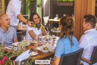 eine Gruppe von Menschen, die in einem Restaurant an einem Tisch sitzen in der Unterkunft Luxury Harbour Suite With Private Parking in Loosdrecht